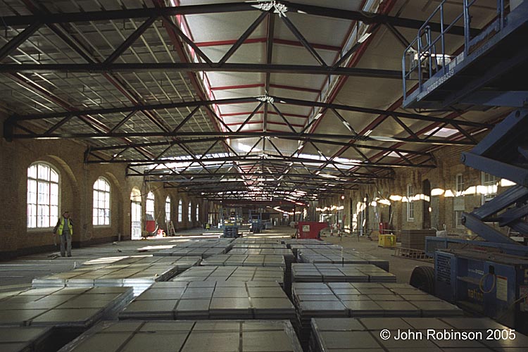 Looking west along Drill Hall, piles of floor tiles in foreground
